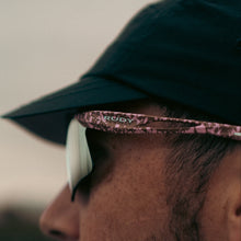 Load image into Gallery viewer, Close-up of a person wearing a green cap and sunglasses with a blurred background
